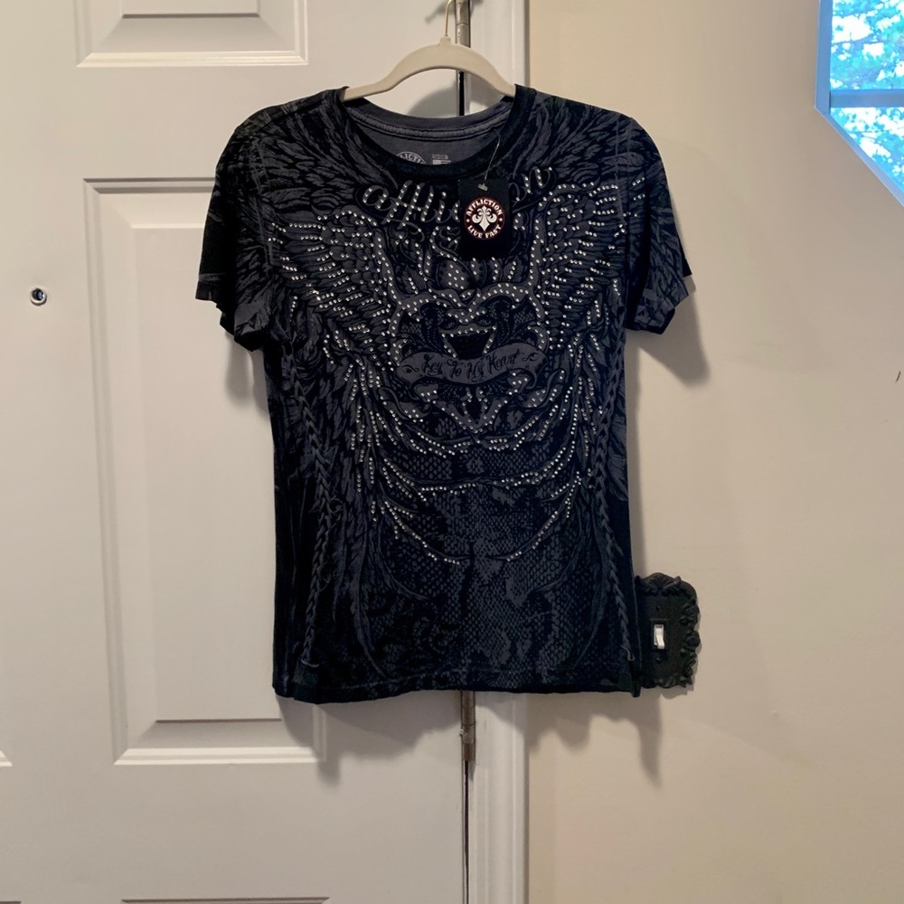 New shirt with tags. Lots of feather designs, shiny grommets front & back.